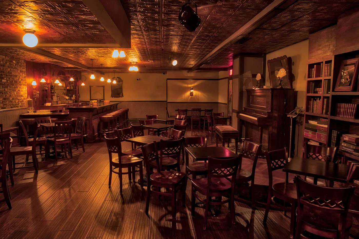 Warm lamplight, polished wood, and intimate tables inside the Palace Theater’s speakeasy bar